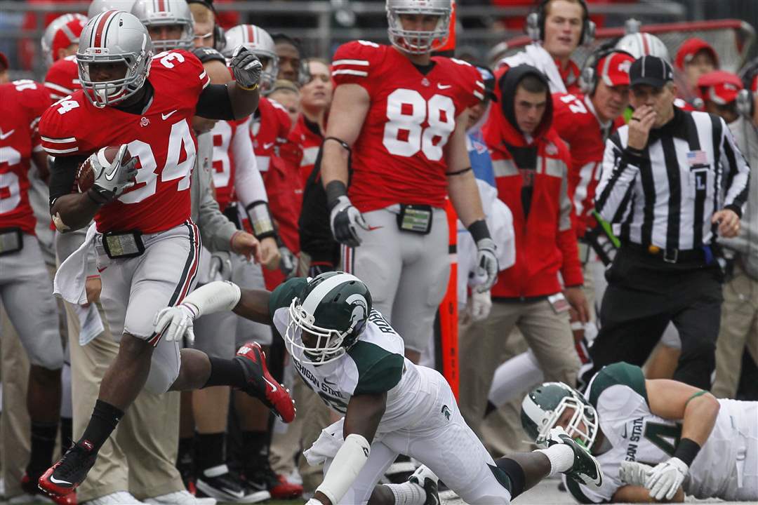 Ohio-State-tailback-Carlos-Hyde-slips-past-Trenton-Robinson