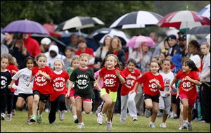 Kindergartners and first grade girls leave the starting line for a half mile race on a course set up at Secor Metropark. They competed despite last week's rain.