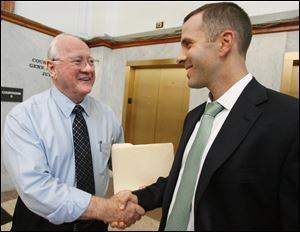 Bob Bennett, left, shakes hands with Tony Packo III after Judge Gene Zmuda chose Bennett's TP Food LLC to purchase the Tony Packo's Inc. restaurant chain, in Lucas County Common Pleas Court, Thursday.  Packo and Mr. Tony Packo Jr., withdrew their competing offer for the chain and threw their support behind Bennett. 