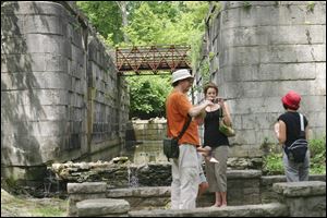 Robert McCord, of Chicago, and his sister Julia McCord, of Bowling Green, look over pictures they took recently of one of the original locks of the Miami & Erie Canal at Side-Cut Metro Park in Maumee.