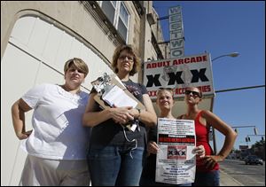 Library Village residents Jodie Banaszak, left, Michelle Glanville, Beth Jones, and Jennifer Lahna join the rally against the not-yet opened adult arcade. A total of about 50 people turned out yesterday.