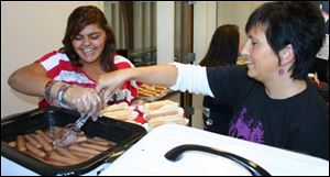 Orchard Center High School senior Kadizjah O'Haver, left, and Principal Stephanie Cavanugh serve franks at the end of Count Day.