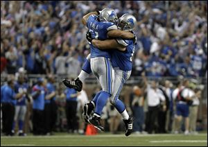 The Lions' Dominic Raiola, left, and Stephen Peterman celebrate a touchdown Monday night. Detroit is 5-0, the first time since 1956.