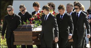 IndyCar drivers Tony Kanaan, left, of Brazil, Scott Dixon, of New Zealand, third from left, and Dario Franchitti,  of Scotland, right, carry the coffin of fellow driver Dan Wheldon after funeral services Saturday, Oct 22, 2011, in St. Petersburg, Fla.  Wheldon was killed Sunday, Oct. 16, 2011, in a fiery 15-car crash at the Las Vegas Motor Speedway.