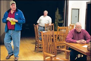 Elmore Mayor Lowell Krumnow, 54, walks past his
brother James, 58, a village councilman, who is being interviewed after a meet-the-candidates forum. Both are Republicans running in a nonpartisan race.