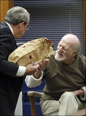 Robert Bowman, right, examines a Spider-man doll as Assistant Lucas County prosecutor John Weglian, left, cross-examines him.