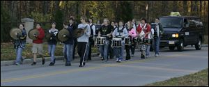 Percussionists from the Northview band lead the bus carrying the Northview girls' cross country team as they are bid farewell.