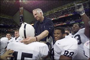 Then Penn State defensive coordinator Jerry Sandusky reaches out to defensive back Brandon Scott (45) as he is carried by players, including Jason Wallace (88), after they defeated Texas A&M in the Alamo Bowl, in San Antonio, Texas, in this Dec. 28, 1999, file photo.