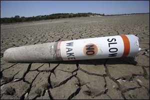 A buoy sits high and dry in August at Benbrook Lake in Benbrook, Texas. Freakish weather, from an October snowstorm to the long-lasting drought in the U.S. Southwest, is striking more often, a special international report says.