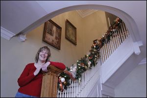 Mary Bennett on the staircase of her home on display for the Tours de Noel.