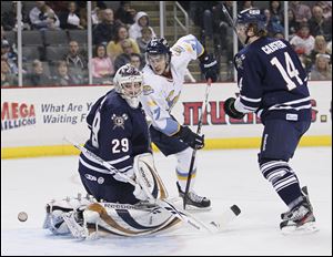 Toledo Walleye player Trevor Parkes (27) watches as the puck gets past Greenville Road Warriors goalie Nic Riopel (29) during the first period at Huntington Center, Friday.  At right is Road Warrier Jeff Caister (14).