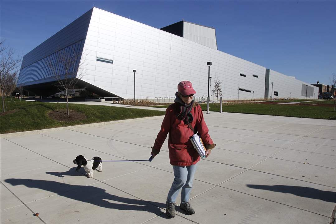 Karen-Kakas-an-art-education-instructor-walks-her-dog-past-the-new-Wolfe-Center