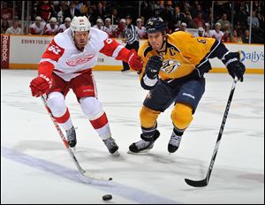 Johan Franzen of the Detroit Red Wings races Shea Weber of the Nashville Predators for the puck.