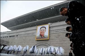 Pyongyang citizens pay respects Wednesday in front of a portrait of late North Korean leader Kim Jong Il at the Grand People's Study House in Kim Il Sung Square in Pyongyang, North Korea. The portrait was hung in the spot where the portrait of late President Kim Il Sung usually hangs. 