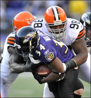 Baltimore Ravens running back Ricky Williams (34) tries to break free from Cleveland Browns defenders D'Qwell Jackson, left, and Phillip Taylor in the second half of an NFL football game in Baltimore Saturday.