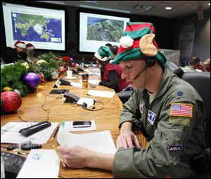 Air Force Lt. Col. David Hanson, of Chicago, takes a phone call from a child in Florida at the Santa Tracking Operations Center at Peterson Air Force Base near Colorado Springs, Colo.