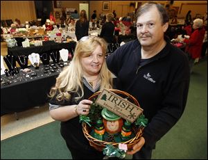 Tania and Garry O'Brien, at a recent sale at an Elks lodge in Toledo, display a basket assembled by an exhibitor. The couple have donated to Humane Ohio and Cherry Street Mission Ministries. 