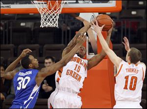 Bowling Green State University forward A'uston Calhoun (15) pulls in a rebound against Buffalo forward Titus Robinson (30) Saturday.