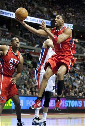 Atlanta Hawks' Tracy McGrady (1) goes past Detroit Pistons' Austin Daye for a basket as Hawks' Jason Collins (34) looks on in the first half of an NBA basketball game on Friday, Jan. 27, 2012, in Auburn Hills, Mich. (AP Photo/Duane Burleson)