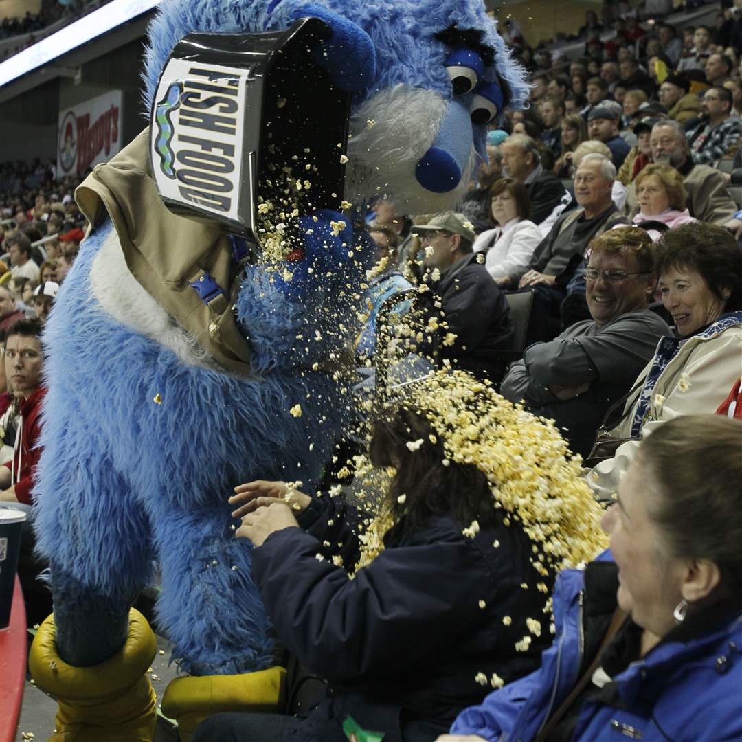 Toledo-mascot-Cat-Trick-dumps-a-bucket-of-popcorn-on-fan-Sylvia-Spencer