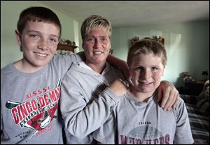 Tricia Askins and her sons Jared Rettig, 12, left, and Jacob Rettig, 10, moved into her parents’ home at the fi rst of the year after she was laid off three times from the same factory job.