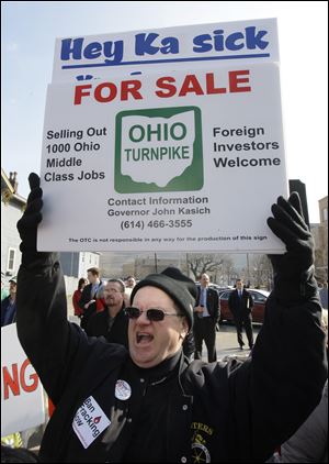 Mark Cleland of Austintown, Ohio, joins protesters gathered outside Wells Academy in Steubenville.