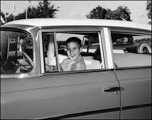 10-year-old Mitt gets behind the wheel of a Nash, an automobile manufactured by American Motors Corp., of which his father, George, was president. Young Romney had a great interest in cars.