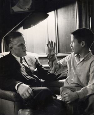 A young Mitt Romney talks with his father, George, at their Detroit-area home in 1957. 