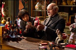 Asa Butterfield, left, portrays Hugo Cabret, and Ben Kingsley plays George Melies in a scene from 'Hugo.'