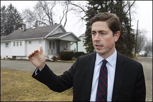 Democratic hopeful Graham Veysey of Cleveland holds a news conference in front of Marcy Kaptur's house in Toledo, one of the targets of the latest super PAC television ad. 