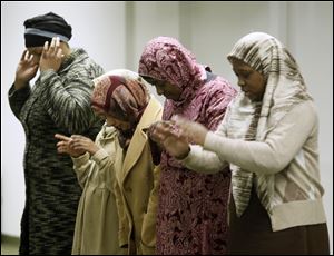 Muslim women pray at Toledo Masjid Al-Islam, which held its first open house last weekend since moving from Ewing Street to 722 E. Bancroft St., just east of Cherry Street. The Bancroft Street building was the site of the first mosque in Toledo when it opened in 1954, but its members moved to Perrysburg Township in 1983. The old building was used as office  space and then stood vacant until Toledo Masjid Al-Islam bought it and renovated it nearly two years ago.