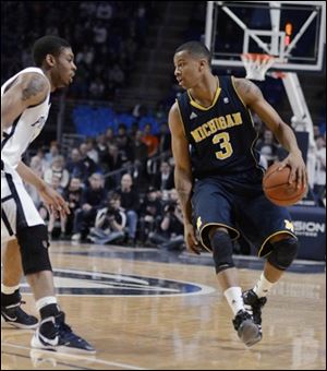 Michigan's Trey Burke (3) looks for room around Penn State's Jermaine Marshall in the second half.