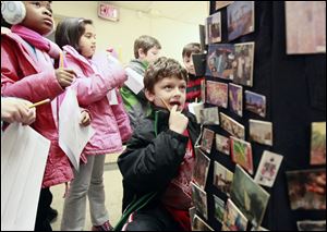 Alex Retholtz looks to identify some of the art pins. The one child from each grade level who identifies the most pins has his or her name announced. 