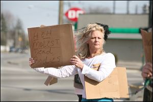 Cindy Putman protests outside the H.H. Birkenkamp Funeral Home on Tremainsville Road, where family says a corpse was abused.