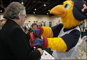 Bob Cairl of Toledo’s Architectural Artifacts Inc. appraises as ‘priceless’ a bat autographed by Toledo Mud Hens Mascot Muddy at the Professional Remodelers Organization Home Improvement  & Garden Show at SeaGate Convention Centre in downtown Toledo. The threeday show continues Sunday.