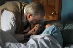 Dr. Herbert Lerner kisses his wife, Dr. Ruth Lerner, in her bed at their son's Berwyn, Ill., home. She has vascular dementia, which deprives the brain of food and oxygen and has taken her ability to communicate or care for herself. 