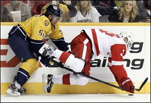 Nashville Predators defenseman Francis Bouillon (51) checks Detroit Red Wings left wing Jan Mursak, right, of Slovenia, in the first period of an NHL hockey game on Saturday.