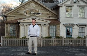 Bronson Pinchot poses in front of the Decker House, one of six properties he owns in Harford, Pa. Best-known for his role on a television sitcom, he is on the DIY Network's 'The Bronson Pinchot Project.'