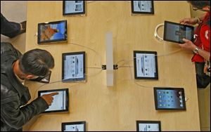 People try out the Apple iPad in a Paris store.