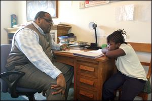 Keith Jordan taks with Marketta Woodward, 8, a second grader at Pickett Academy, at the Padua Center on Nebraska Avenue in Toledo. Keith Jordan is currently single and spends much of his time working and volunteering. 