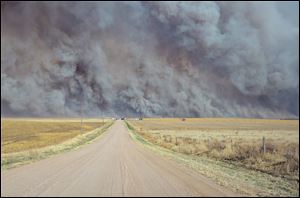 A wildfire Sunday sends up a huge wall of smoke, forcing authorities to temporarily close a section of U.S. Highway 34 east of Yuma County, Colo., when the fire filled the skies with so much smoke that firefighters couldn't see the flames. 