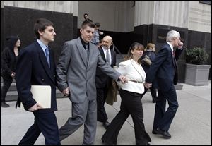 From left, Joshua Stone, David Stone Jr., Tina Stone and David Stone, Sr. leave the federal courthouse in Detroit, Thursday.  Stone Sr., a Michigan militia leader and his son, Joshua, each pleaded guilty Thursday to illegally possessing a machine gun.