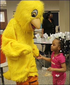 Michiay Dulay, 5, visits with Jacob Sigman, 17 a junior from Toeldo, who's inside the Easter chick costume. 