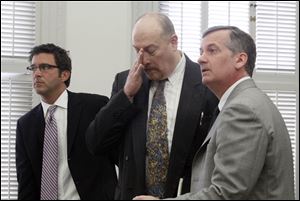 William Buzzell, flanked by attorneys Neil McElroy, left, and Jeff Helmick, reacts as he hears he must spend the next four years in prison.