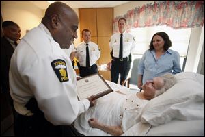 Toledo police Chief Derrick Diggs honors Evelyn Feiger with an award recognizing her volunteer efforts to the city of Toledo. Ms. Feiger is a resident of Lutheran Village at Wolf Creek in Springfield Township. With Chief Diggs are Lts. James Brown and Mark King and Bea Harris, a family friend.