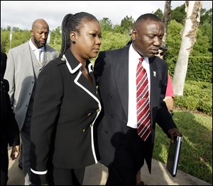 Tracy Martin, back left, and Sybrina Fulton, center, parents of Trayvon Martin, arrive Friday with attorney Benjamin Crump at the Seminole County Criminal Justice Center for a bond hearing for George Zimmerman,  the neighborhood watch volunteer charged with murdering their son.