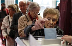 A woman casts her ballot during the first round of the French elections in Lille, northern France, Sunday.