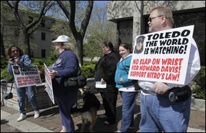 Protesters, from left, Molly LaMountain of Whitehouse, Toledoans Barb Newman, Elizabeth Nirschl, and Pamala Moore and Mike Smeck of Amherst, Ohio, rally outside Toledo Municipal Court. The rally organizer, Mr. Smeck, was disappointed Howard Davis will be permitted to keep his remaining dogs.