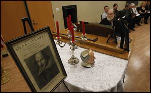 A portrait of William Shakespeare is present during An Evening with Shakespeare at the Bedford Branch Library in Temperance, Mich. Playing the piano is Farnham Scott.