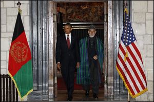 President Barack Obama and Afghan President Hamid Karzai arrive before signing a strategic partnership agreement, Tuesday, May 1, 2012, at the presidential palace in Kabul, Afghanistan.